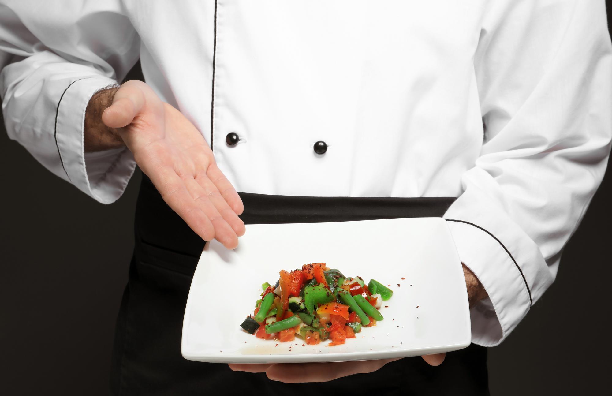 Chef che prepara un piatto raffinato in cucina moderna